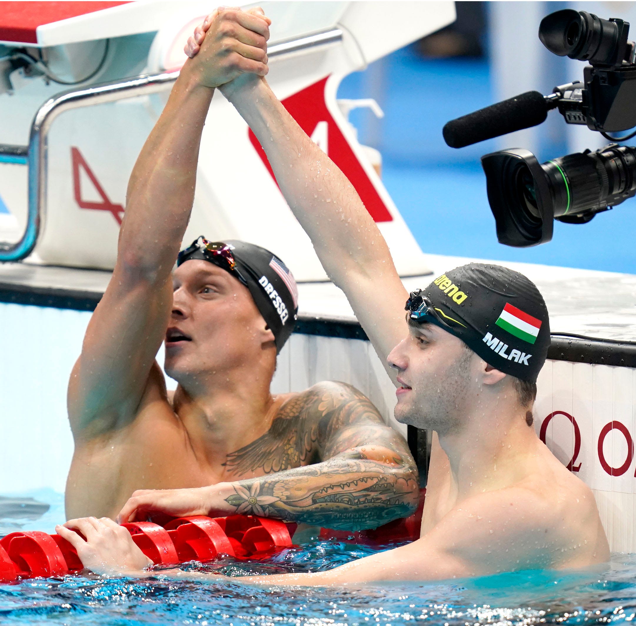 Caeleb Dressel, left, and Kristof Milak of Hungary celebrate after finishing first and second in the men's 100 butterfly final during the Tokyo 2020 Olympics on July 31.